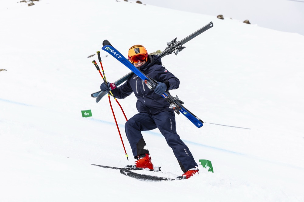 Jan Farrell carrying two pairs of skis between runs at Vars