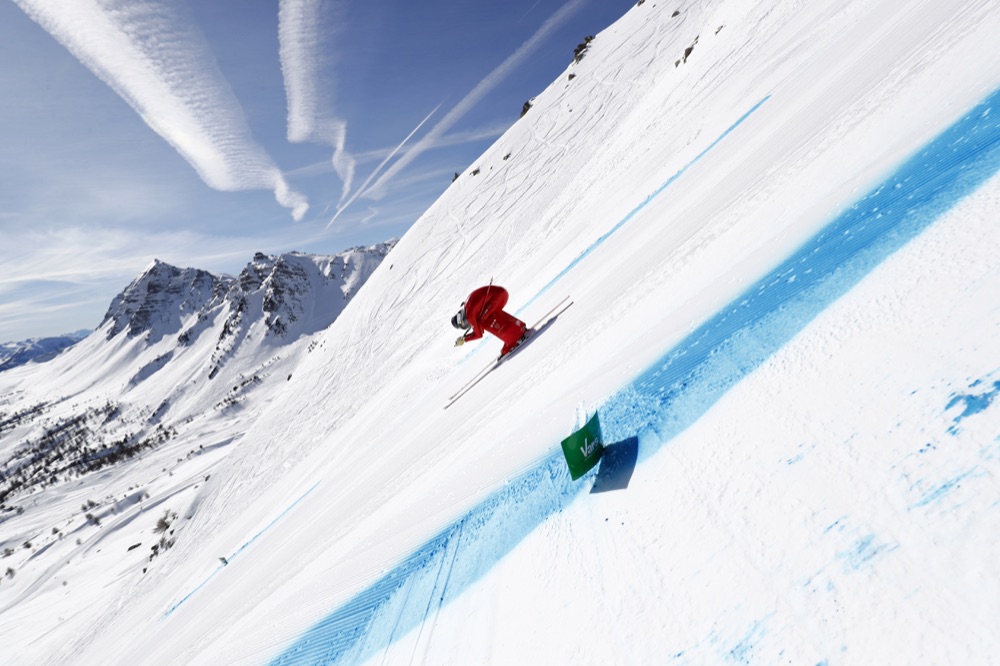 Jan Farrell in a full tuck on the Vars speed track, mountains behind